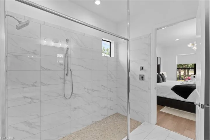 Ensuite bathroom featuring a marble finish shower, ensuite bath, and recessed lighting