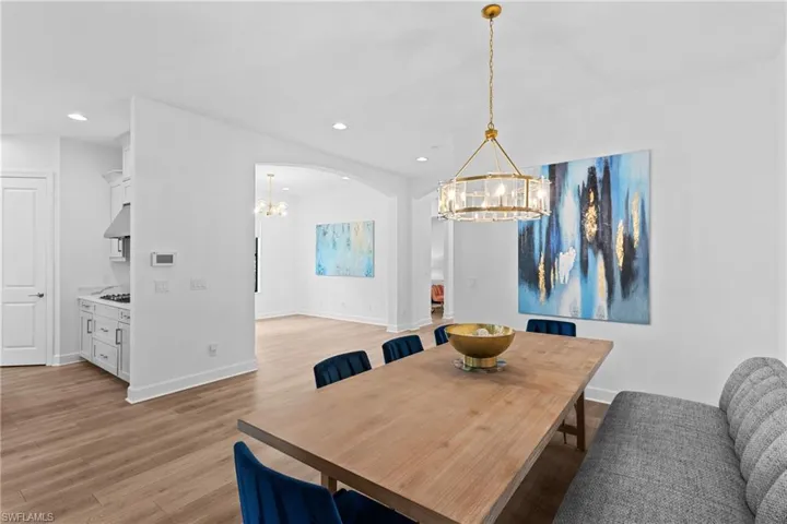 Dining area with an inviting chandelier, baseboards, light wood finished floors, and recessed lighting