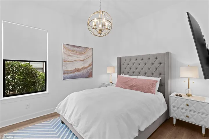 Bedroom featuring a notable chandelier, baseboards, and wood finished floors