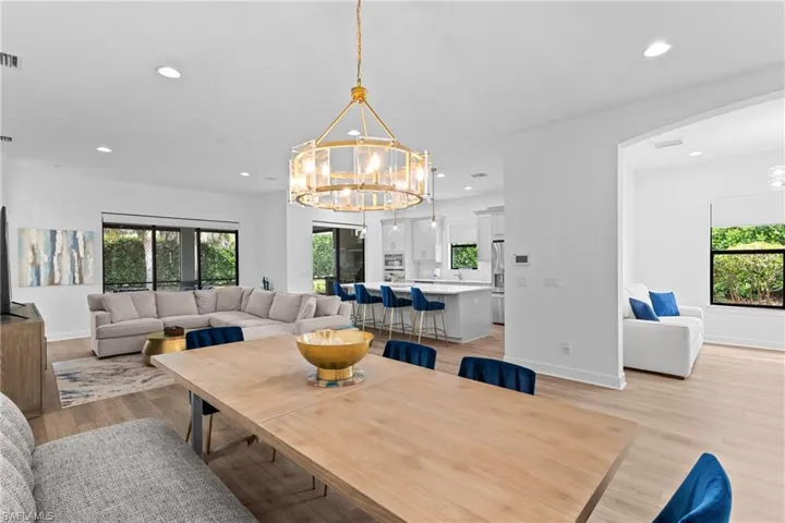 Dining room with plenty of natural light, a notable chandelier, and light wood-type flooring