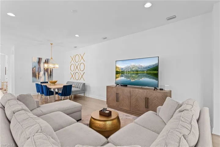 Living area with recessed lighting, baseboards, a chandelier, visible vents, and wood finished floors