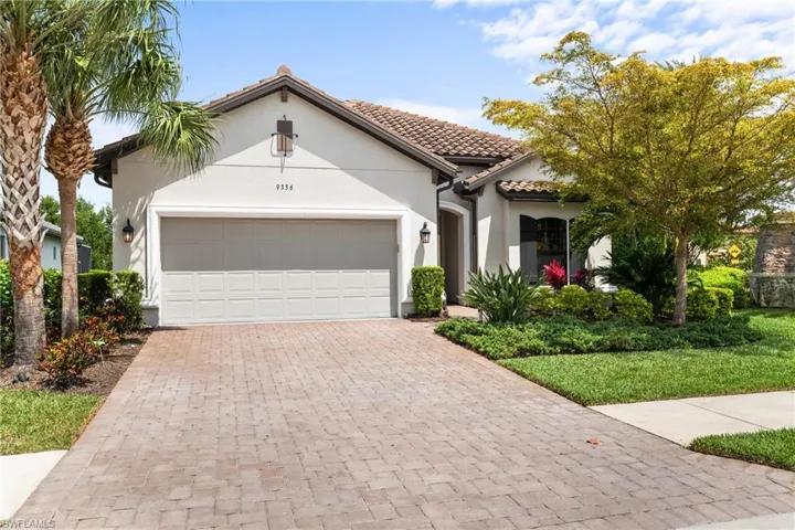 Mediterranean / spanish-style house with a tiled roof, decorative driveway, stucco siding, and an attached garage