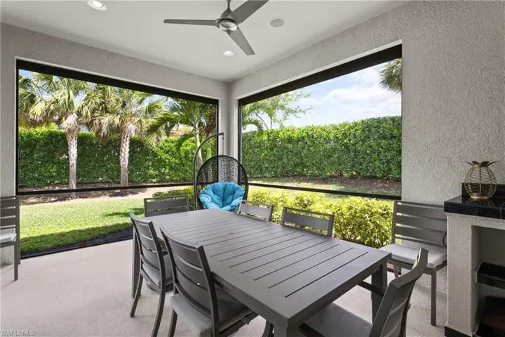 Sunroom / solarium with outdoor dining area and a ceiling fan
