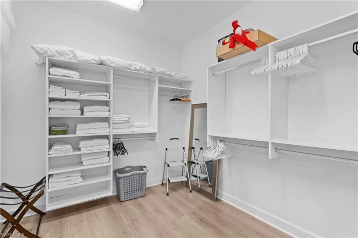 Walk in closet with wood finished floors