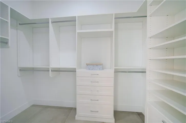 Walk in closet with light tile patterned flooring