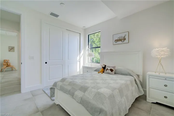 Tiled bedroom featuring a closet