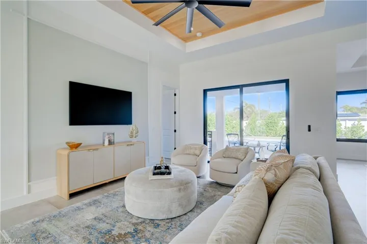 Living room featuring a healthy amount of sunlight, wooden ceiling, and a tray ceiling