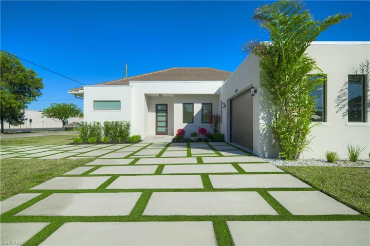 Back of house with a garage and a lawn