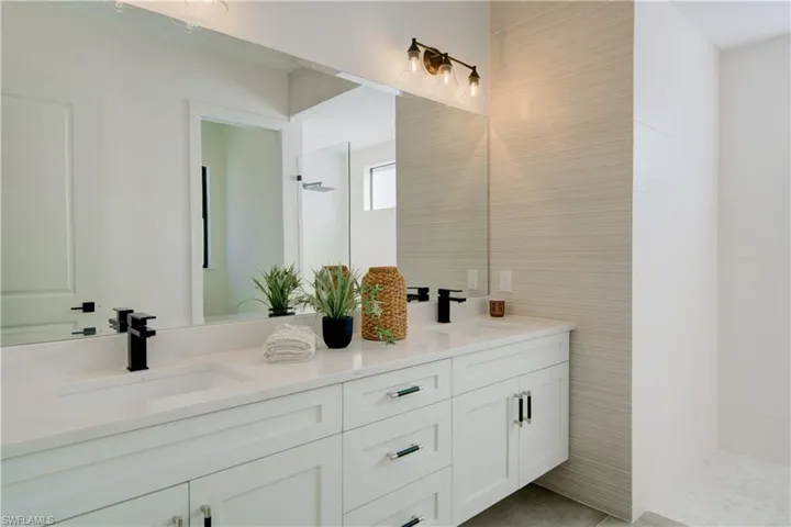 Bathroom with a shower, vanity, and tile walls
