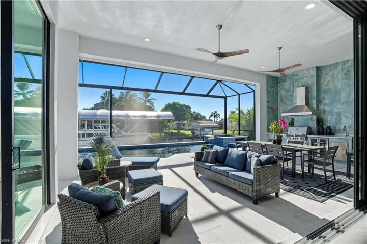 View of patio featuring area for grilling, a sunroom, outdoor lounge area, glass enclosure, and ceiling fan