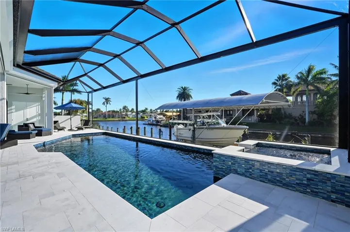 Outdoor pool featuring a sunroom, a water view, a patio area, a boat dock, and a lanai