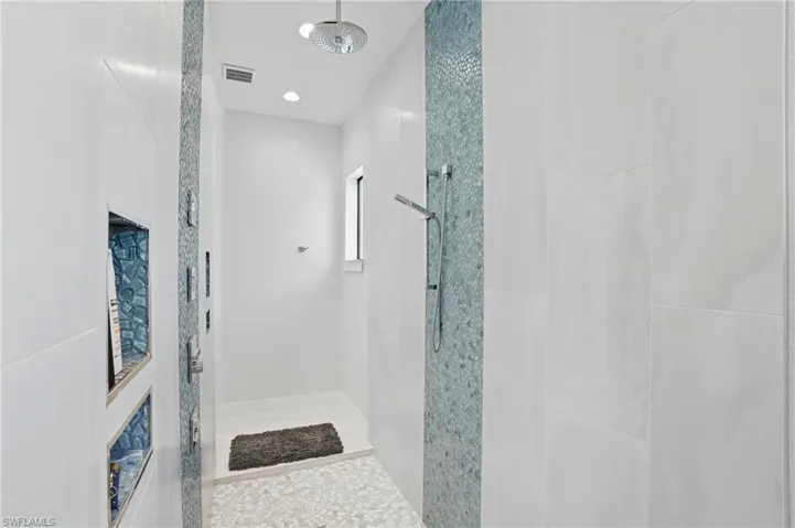 Full bathroom with tiled shower and recessed lighting