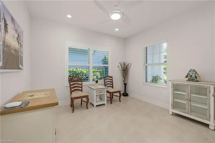 Living area with light tile patterned flooring, a healthy amount of sunlight, and ceiling fan
