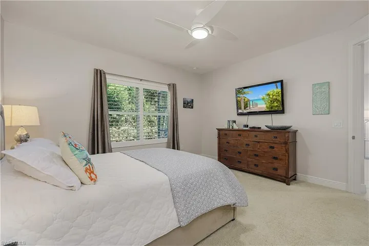 Bedroom with light colored carpet and ceiling fan