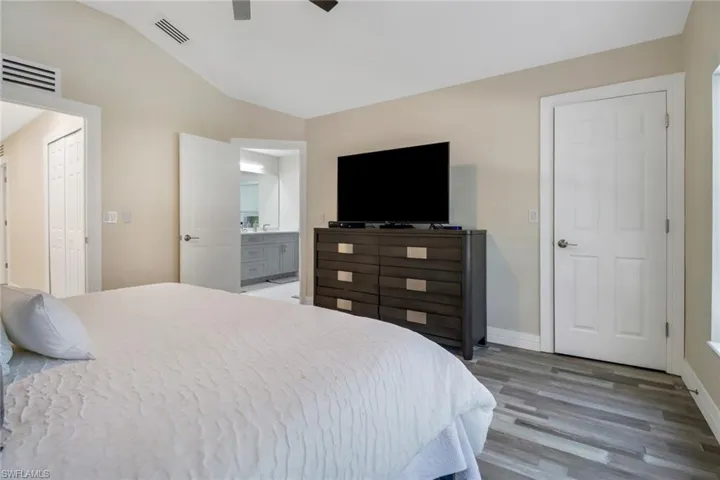 Primary Bedroom with en suite bathroom and hardwood / wood-style floors
