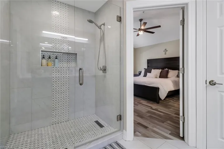 Bathroom with walk in shower, wood-type flooring, and ceiling fan