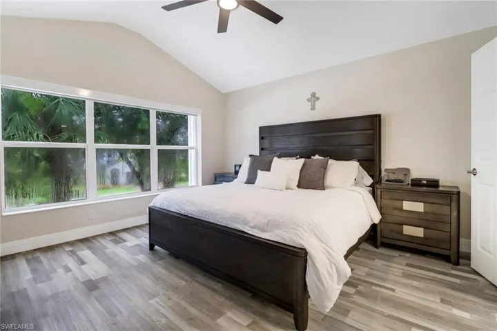 Spacious Primary Bedroom with light wood-style floors, large windows allowing sunlight to stream into the room