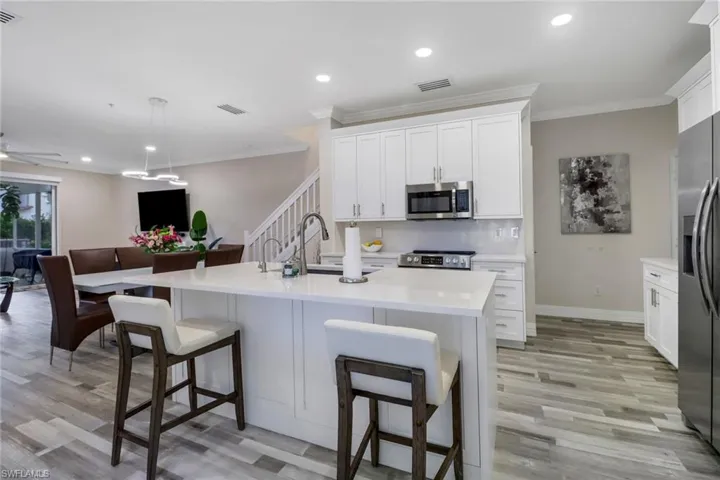 Chef's Kitchen with white cabinetry, a center island with ample prep area, light wood-style floors, and stainless steel appliances