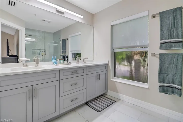 Bathroom with tile patterned floors and dual bowl vanity