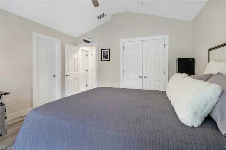 Bedroom featuring vaulted ceiling, hardwood / wood-style floors, and ceiling fan