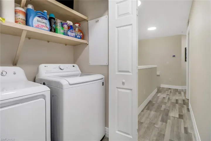 Laundry area featuring washer and clothes dryer and light hardwood / wood-style floors
