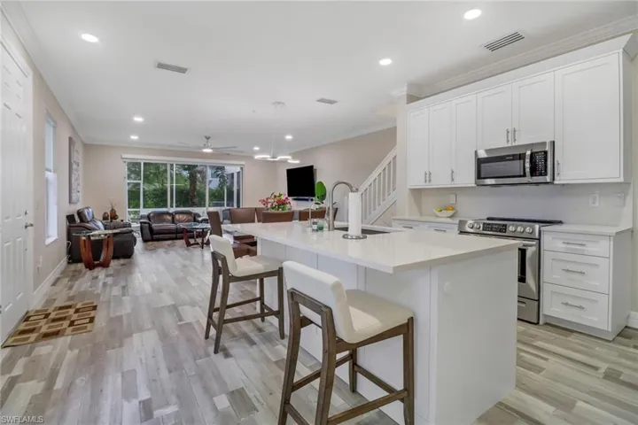 Kitchen featuring stainless steel appliances, light wood-style flooring, white cabinetry, and a kitchen island