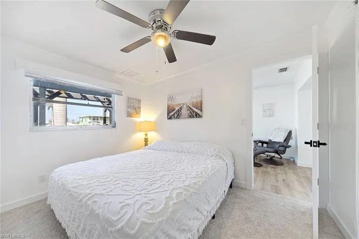 Bedroom with ceiling fan, crown molding, and light colored carpet