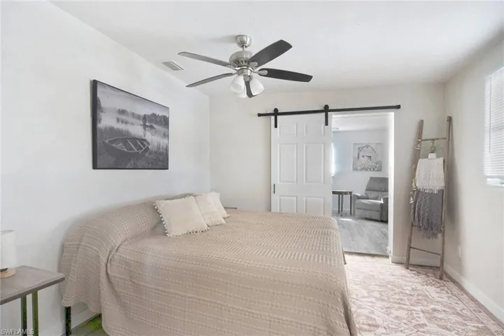 Bedroom featuring a barn door and ceiling fan