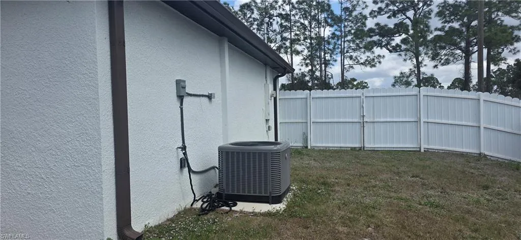 Exterior view of stucco siding and a central AC unit
