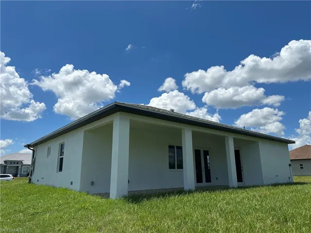 Back of property featuring stucco siding, a yard, and a patio