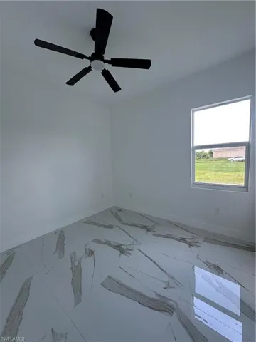 Unfurnished room featuring baseboards and marble finish flooring