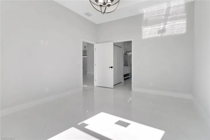 Spare room with visible vents, baseboards, and an inviting chandelier