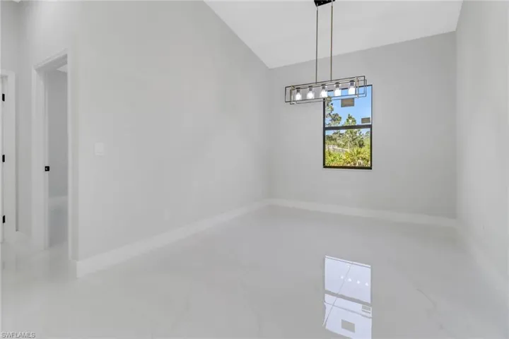 Unfurnished room featuring baseboards, marble finish floor, and a chandelier