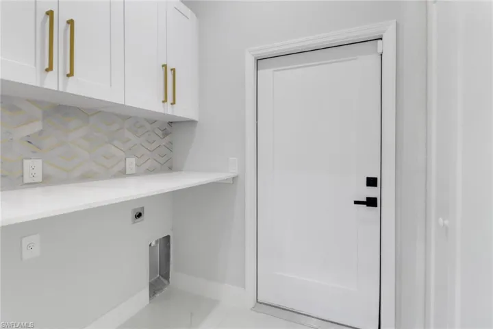 Laundry area with baseboards, cabinet space, and hookup for an electric dryer