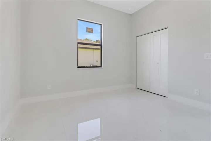 Unfurnished bedroom with baseboards, marble finish floor, and a closet