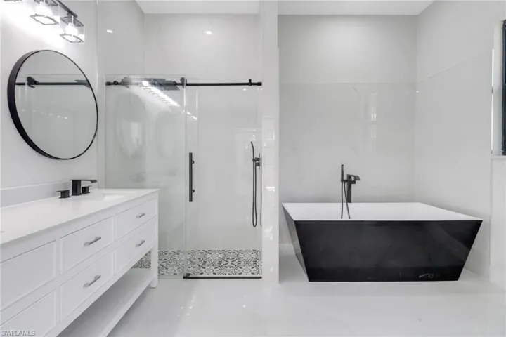 Full bath featuring vanity, a shower stall, and a soaking tub