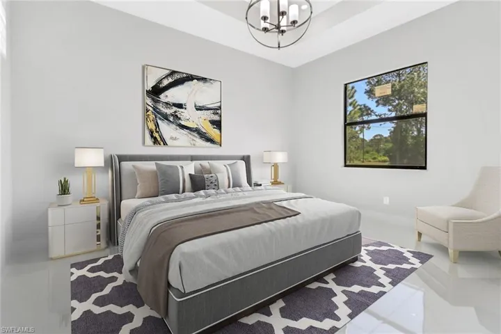 Bedroom featuring a tray ceiling and an inviting chandelier