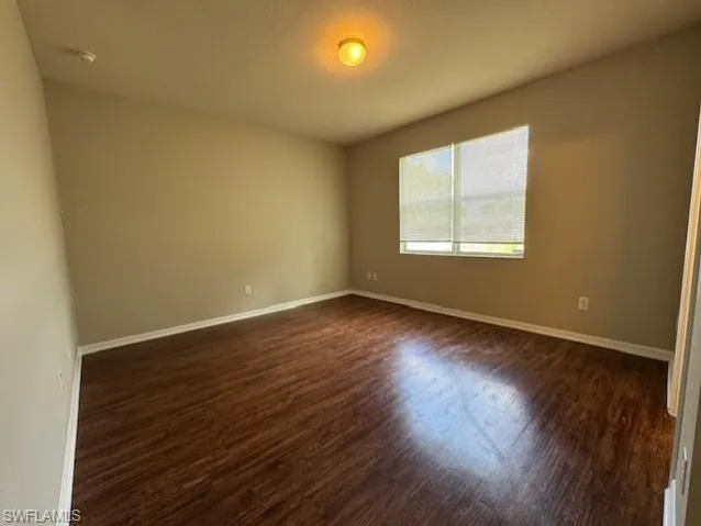 Spare room featuring dark wood-style floors and a textured ceiling