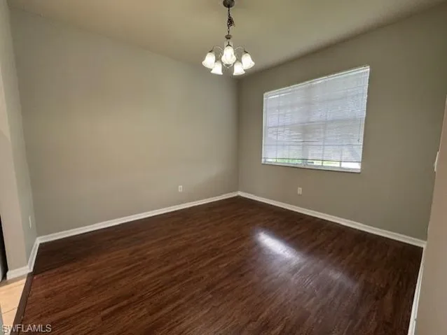 Spare room featuring a chandelier and light wood-style floors