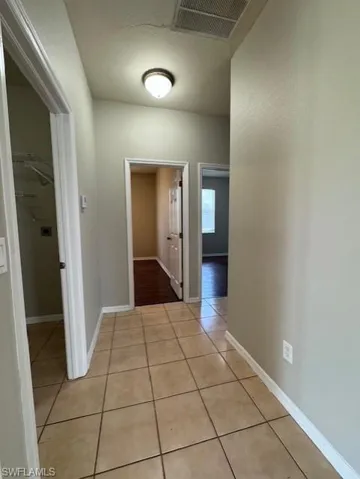 Corridor with light tile patterned floors and baseboards