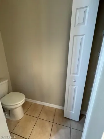 Bathroom with light tile patterned floors and toilet