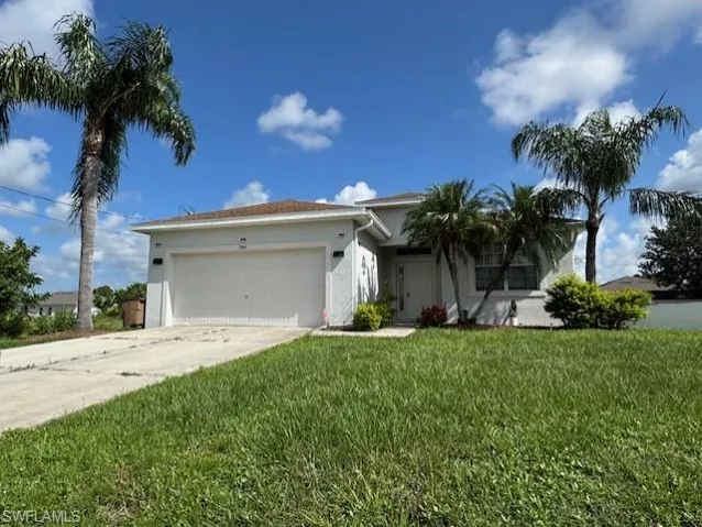 Ranch-style house with stucco siding, concrete driveway, an attached garage, and a front yard
