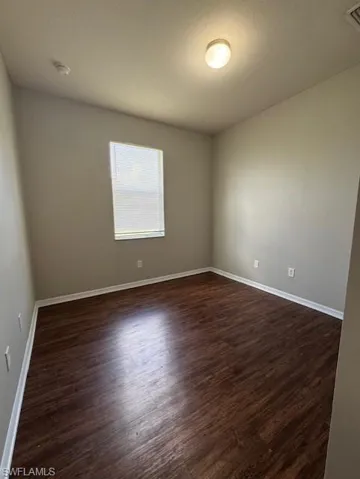Unfurnished room featuring dark wood-style floors