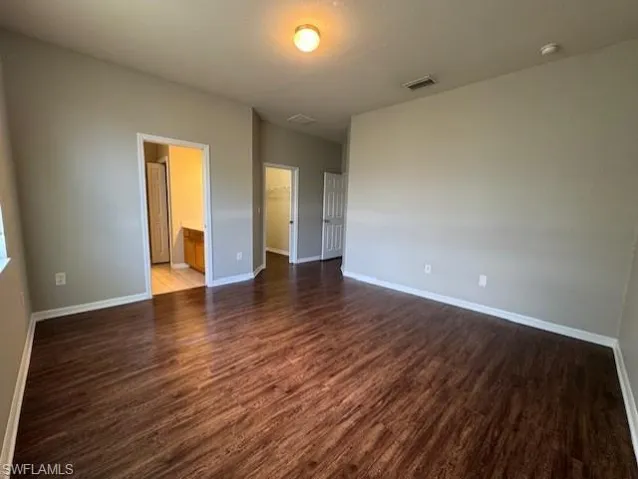 Spare room with dark wood finished floors and baseboards