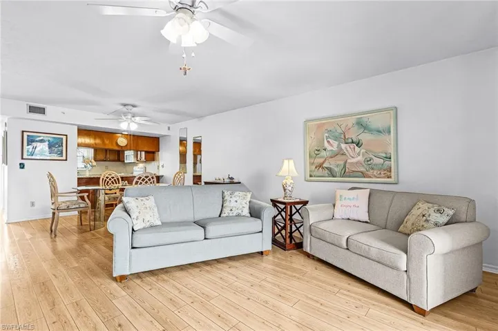 Spacious living area featuring wood-finish flooring and ceiling fans