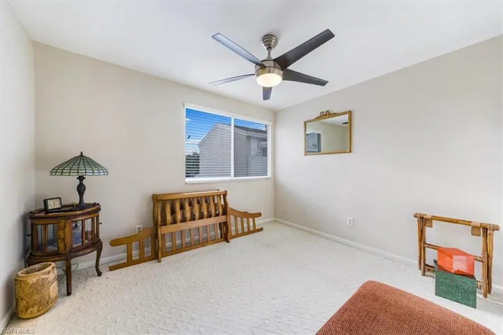 Living area with a ceiling fan and carpet