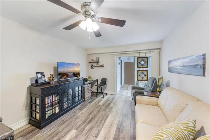 Living area with wood finished floors and ceiling fan