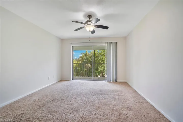 Carpeted empty room with a ceiling fan and baseboards