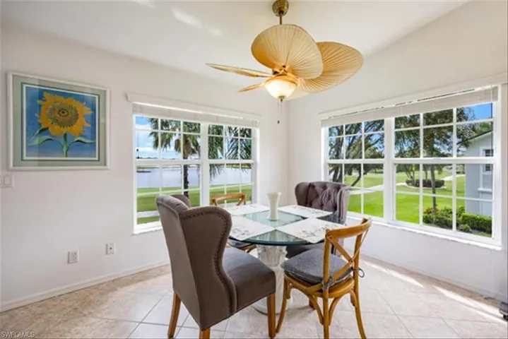 Tiled dining area with ceiling fan and lofted ceiling