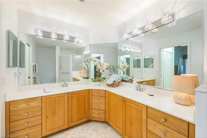 Bathroom with vanity, tile patterned flooring, a shower with shower door, and toilet